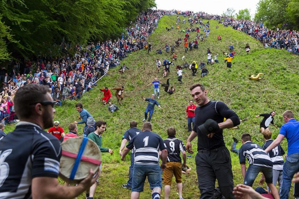 Ежегодные мероприятия. Куперсхилдская сырная гонка. Cooper's Hill Cheese-Rolling and Wake. Cheese Rolling, Cooper’s Hill, Gloucestershire. Сырные гонки (Cheese Rolling).