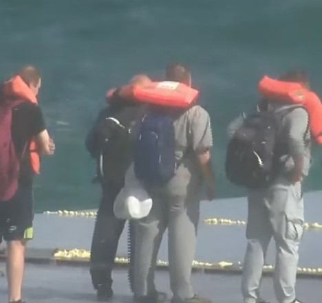 Gemiden kurtarılan mürettebat, can yelekleriyle güvenli bir alana alındı.