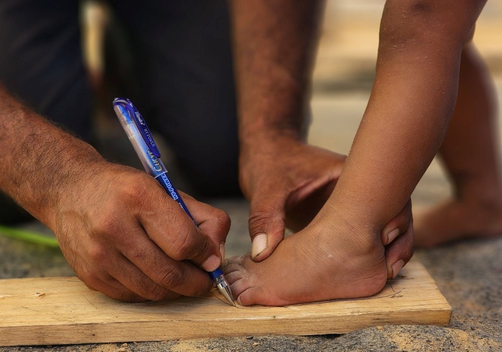 Fələstinli ayaqqabıçı İsrailin hücumu altında olan Qəzzada uşaqlar üçün taxta başmaq düzəldir - 4