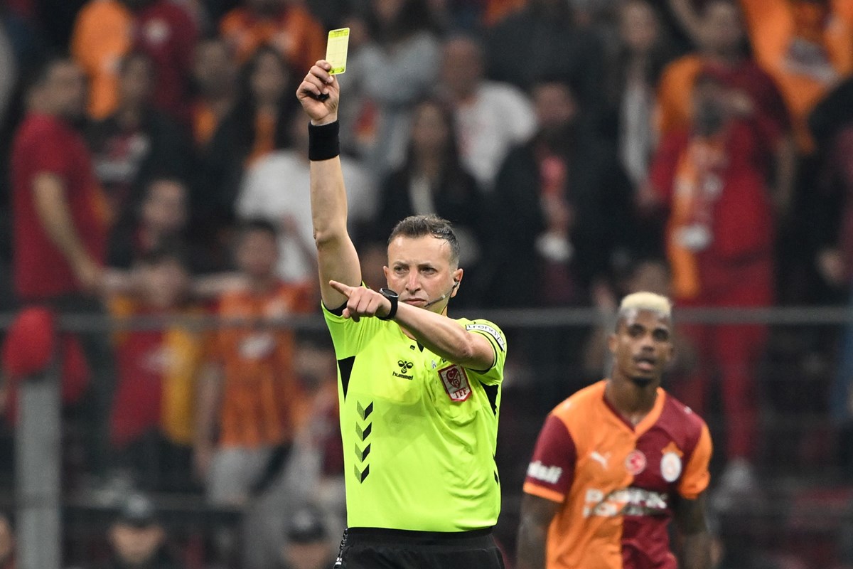 Galatasaray-Beşiktaş derbisinin hakemi Yasin Kol, sarı kart gösterirken...