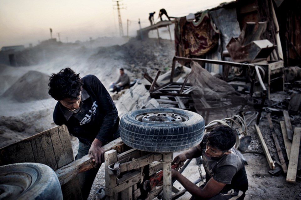 Gazzeliler 2008–2009 tarihli Dökme Kurşun Harekâtı’ndan kalma dağ gibi molozları toplamak için bir eşek arabasını tamir ediyor. Bu moloz geridönüşümle inşaatlarda kullanılıyor.