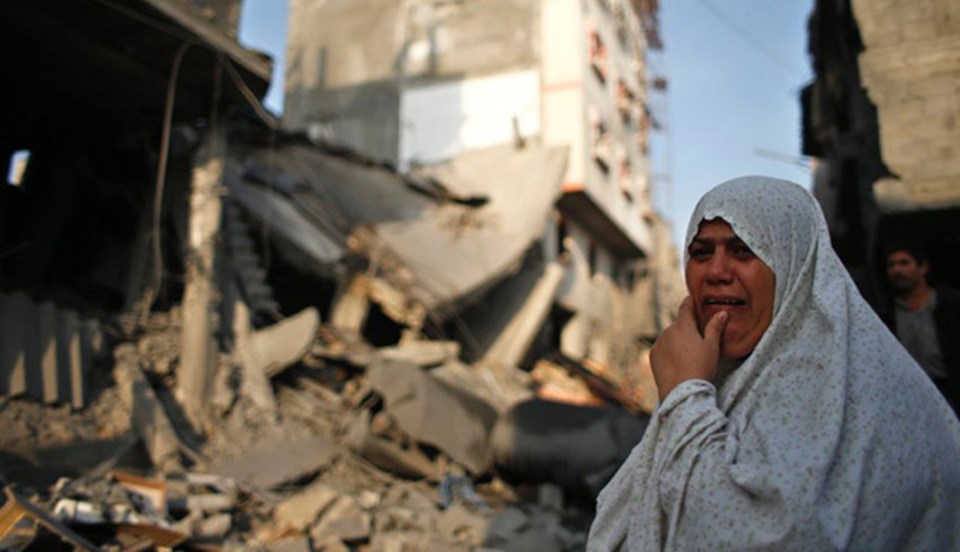Gazze, İsrail tarafından bombalanırken, Filistinli bir kadın çaresizlikten gözyaşı döküyor.