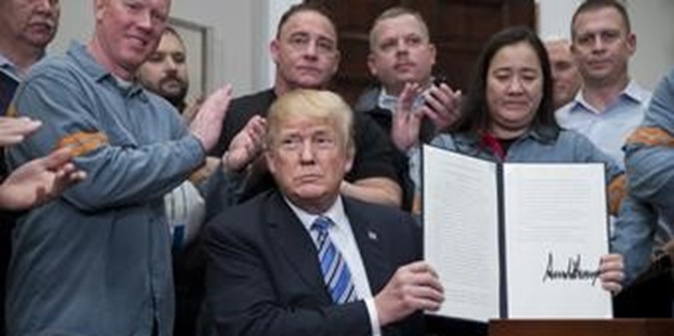 ABD Başkanı Donald Trump, ithal edilen çelik ile alüminyuma ek gümrük vergisi uygulama kararını 8 Mart'ta imzaladıktan sonra basın mensuplarına gösteriyor