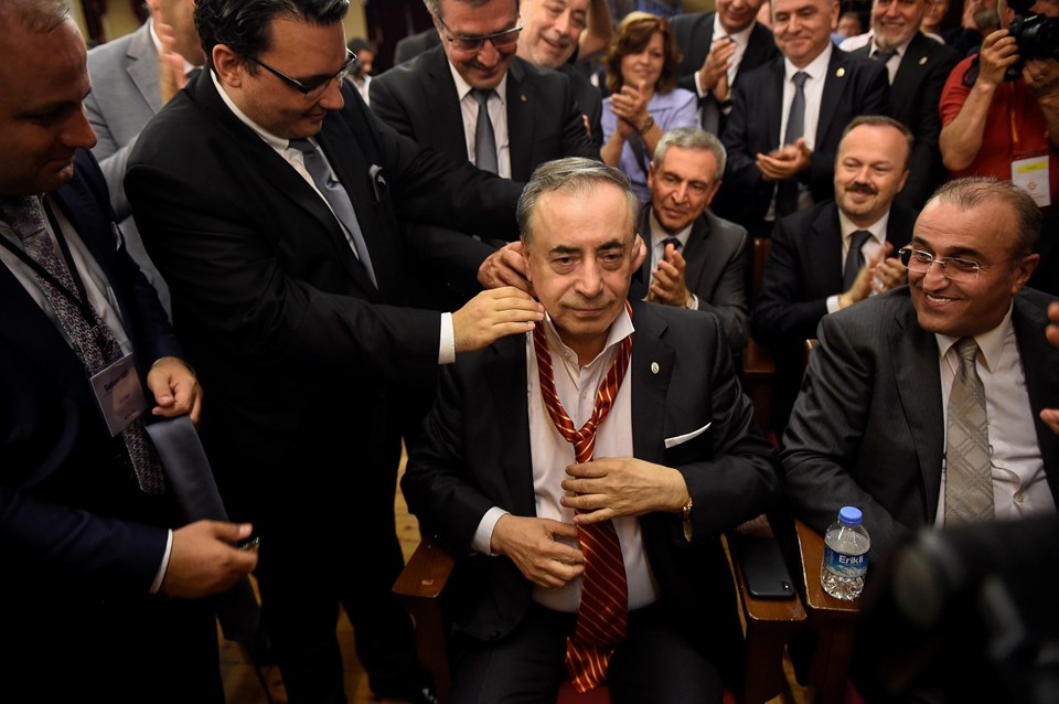 Cengiz, gri kravatı çıkararak sarı kırmızı kravatı taktı.