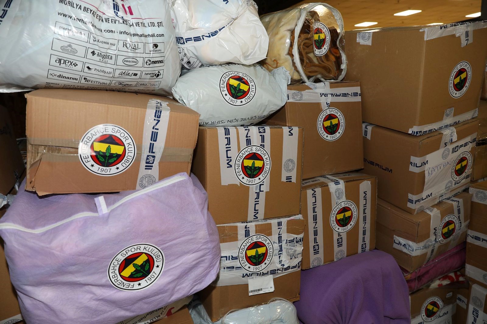 <strong>SARI-LACİVERTLİ SPORCULARDAN DESTEK</strong><br /><br />Fenerbahçe Spor Kulübü’nün başlattığı yardım kampanyası kapsamında toplanan yardım malzemelerinin ilk bölümü deprem bölgesine doğru yola çıktı.<br /><br />Bu doğrultuda Fenerbahçe Spor Kulübü’nün başlattığı yardım kampanyasına vatandaşlar büyük ilgi gösterdi. Vatandaşlar tarafından Ülker Stadyumu Fenerbahçe Şükrü Saracoğlu Spor Kompleksi Kuzey Tribünü’ne getirilen battaniye, kazak, atkı, bere gibi kışlık malzemelerin yanı sıra temizlik ve erzak malzemeleri yoğun çalışmaların ardından istiflenerek kolilendi. Yaklaşık 750 kolinin oluşmasının ardından malzemelerin ilk bölümünü taşıyan Fenerium TIR’ı Kahramanmaraş’ın Pazarcık ilçesine doğru yola çıktı. <br /><br />Kampanyaya destek olmak üzere stada gelen Fenerbahçeli futbolcu Mert Hakan Yandaş, Fenerbahçe Alagöz Holding Takım Kaptanı Olcay Çakır Turgut ile Fenerbahçe Opet Kadın Voleybol Takımı ve A Milli Kadın Voleybol Takımı Kaptanı Eda Erdem Dündar, paketleme çalışmalarına yardım etti.<br /><br /><br />
