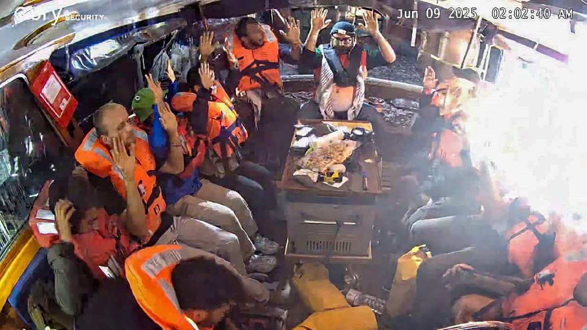 İsrail askerlerinin müdahalesi sırasında aktivistlerin ellerinin havada olduğu görülüyor.